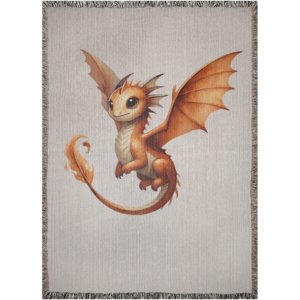 Soft woven tapestry blanket depicting an adorable golden-orange baby fire dragon with warm flame details, open wings, and fringed edges.